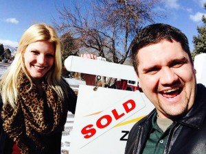 Chris and Megan a few hours before their Boulder real estate closing posing by the SOLD sign