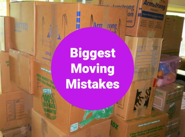 cardboard moving boxes piled high with a purple circle and wording that says biggest moving mistake
