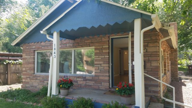 brick and siding bungalow at 1843 23rd street with a blue bird blue covered patio in front f stone and brick facade